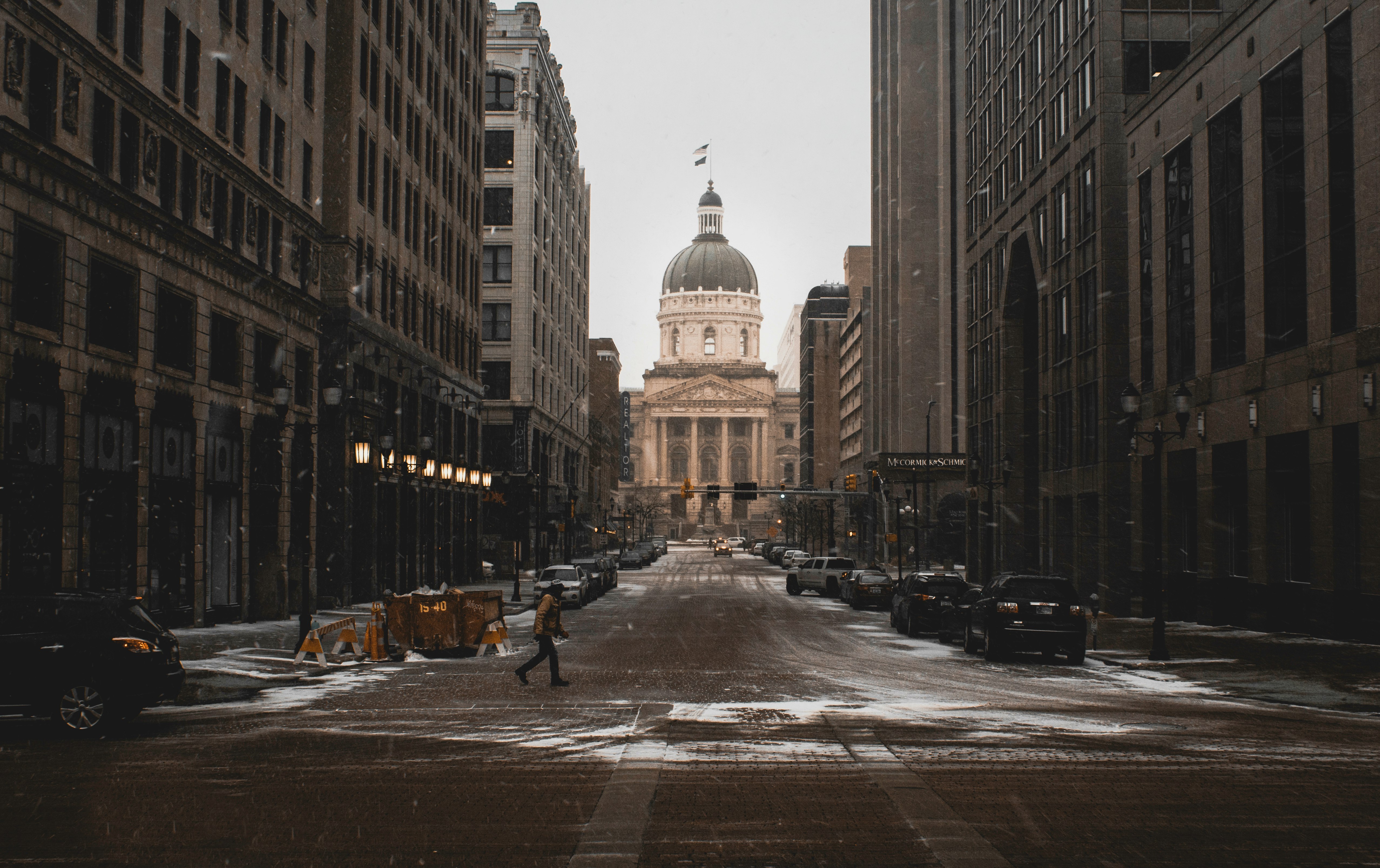 person walking on street between buildings